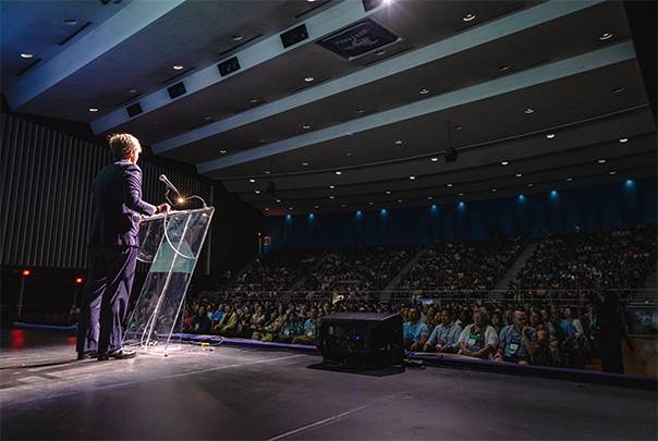 Guest speaker at conference speaking to audience in 
          auditorium.