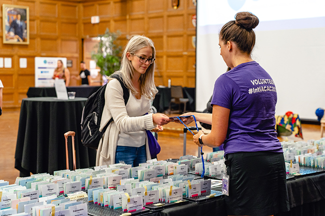 International ACAC conference volunteer handing out name tags