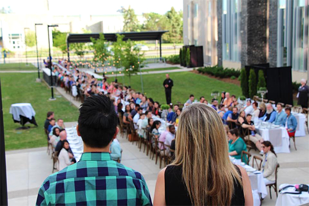 Guests dining outdoors seated at a long banquet style table