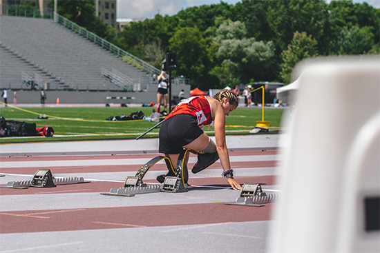 Track athlete at a sporting event ready to start a race.