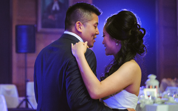 A couple wearing wedding attire, dancing.